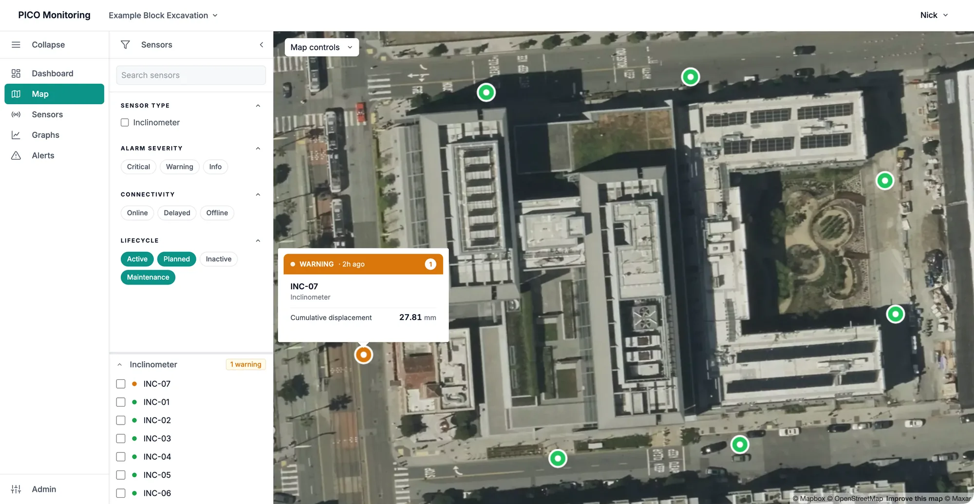 PICO Monitoring site map over aerial imagery of a city block: seven inclinometers ring the excavation, six green and one orange, with the orange sensor's popover showing a warning at 27.81 mm cumulative displacement.